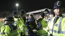 Seorang fans ditahan Polisi setempat setelah berlari memasuki lapangan saat putaran kelima Piala FA antara Arsenal melawan Sutton United di Gander Green Lane stadium, London, (20/2/2017). Arsenal menang 2-0. (AP/Matt Dunham)