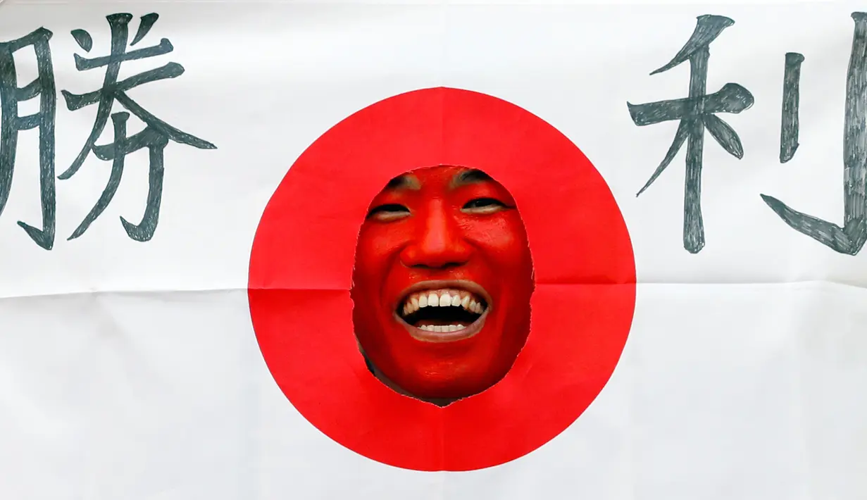 Suporter Jepang mengenakan atribut unik sebelum pertandingan grup H Piala Dunia 2018 melawan Kolombia di Mordovia Arena di Saransk, Rusia (19/6). Para suporter tim samurai biru ini tampil unik saat mendukung negaranya berlaga. (AFP Photo/Jack Guez)