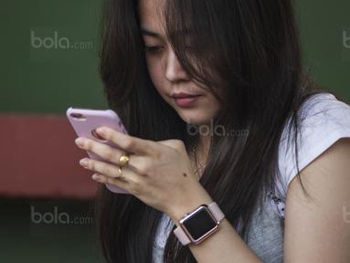 Pacar dari Hansamu Yama, Zakiera Nisha, bermain handphone saat datang menonton latihan Timnas Indonesia U-22 di Lapangan SPH Karawaci, Banten, Jumat (11/8/2017). (Bola.com/Vitalis Yogi Trisna)