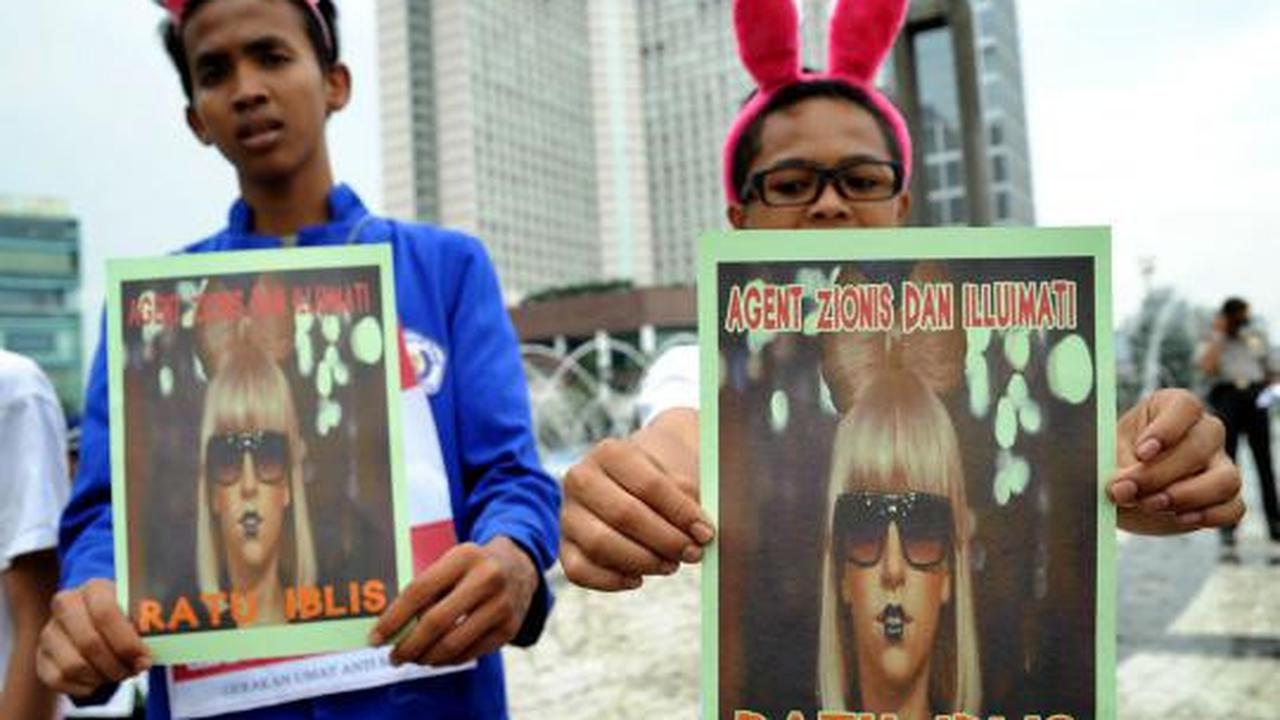 Seorang demonstran membawa poster penolakan konser Lady Gaga pada aksi 