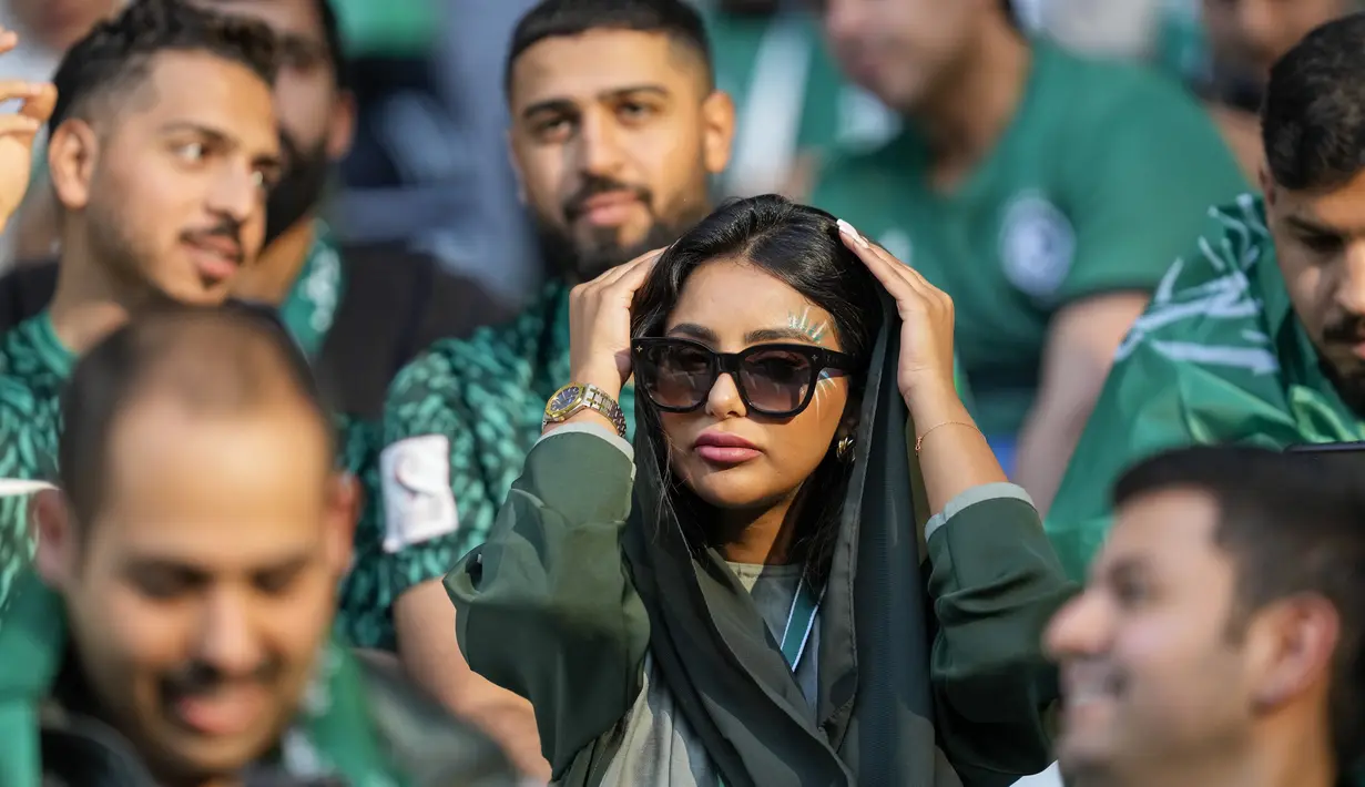 Fans wanita Arab Saudi merapikan rambutnya saat menunggu dimulainya pertandingan grup C Piala Dunia antara Polandia dan Arab Saudi, di Education City Stadium di Al Rayyan, Qatar, Sabtu, 26 November 2022. (AP Photo/Darko Vojinovic)