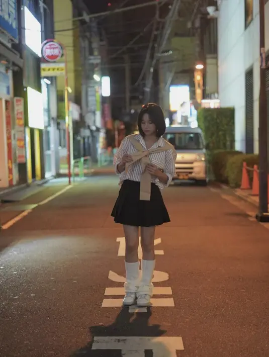 Mengenakan kaos kaki panjang, rok dengan aksen lipat, dan kemeja, juga membuat tampilan terkesan bagai school girl.  [Foto: Instagram/ Zee JKT48]