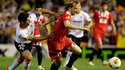 Pemain belakang Valencia, Ricardo Costa (kiri) mencoba menahan laju serangan yang dibangun gelandang Sevilla, Ivan Rakitic saat berlaga di laga kedua semifinal Liga Europa di Stadion Mestalla, Valencia (2/5/2014). (REUTERS/Heino Kalis) 