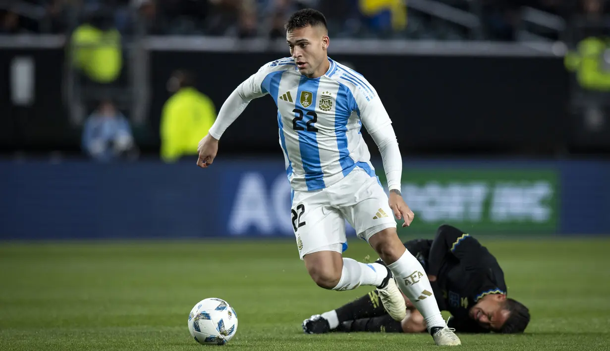 Pemain Argentina, Lautaro Martinez melewati pemain El Savador pada laga FIFA Matchday yang berlangsung di Lincoln Financial Field, Philadelphia, Amerika Serikat, Sabtu (23/03/2024) WIB. La Albiceleste menang dengan skor 3-0. (AFP/Getty Images/Ira L. Black)