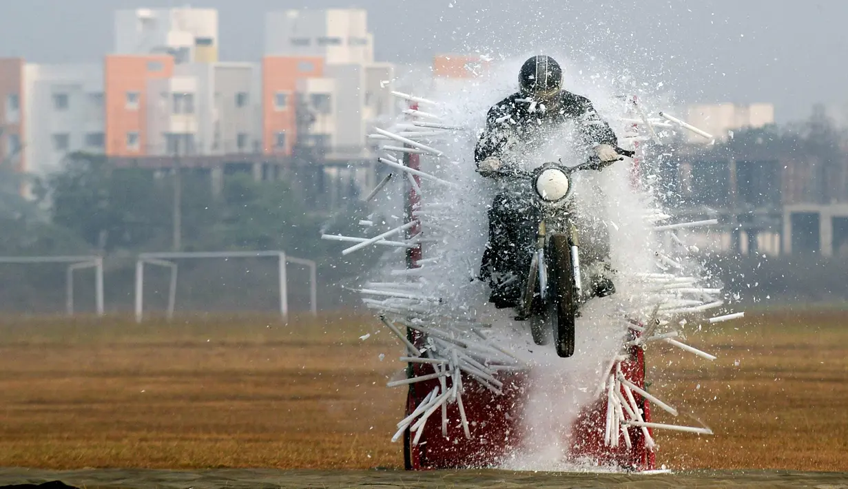 Seorang anggota tentara India dari tim sepeda motor 'Tornado' menabrak lampu selama latihan gabungan di akademi pelatihan perwira di Chennai (9/3). (AFP Photo/Arun Sankar)