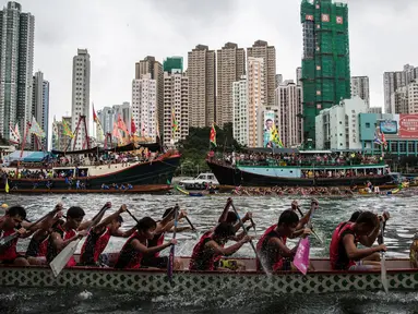 Peserta memacu perahu naga dalam peringatan tahunan Tuen Ng atau Festival Perahu Naga di Hong Kong, Kamis (9/6). Festival tersebut digelar tiap bulan kelima penanggalan Tiongkok. (Anthony WALLACE/AFP)