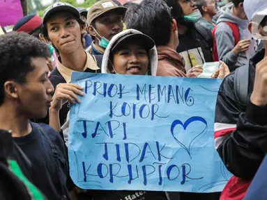 Warga Tanjung Priok membawa poster bertulis 'Priok Memang Kotor Tapi Tidak Koruptor' saat berunjuk rasa di depan Gedung Kemenkumham, Jakarta Selatan, Rabu (22/1/2020). Mereka menuntut Menkumham Yasonna Laoly minta maaf atas ucapannya yang menyinggung warga Tanjung Priok. (Liputan6.com/Faizal Fanani)