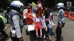 Warga menaiki mobil patroli Dinas Perhubungan Kota Bogor saat aksi mogok sopir angkot 08 dan 09 di kawasan Tugu Kujang, Selasa (13/11). Aksi mogok memprotes pengoperasian angkot modern itu membuat ratusan penumpang terlantar. (Merdeka.com/Arie Basuki)