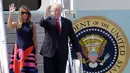 Presiden AS, Donald Trump dan Ibu Negara, Melania Trump turun dari pesawat sambil melambaikan tangan setibanya di Hamburg, Jerman, Kamis (6/7). Sejumlah kepala negara telah tiba di Hamburg jelang pembukaan KTT G20 pada 7-8 Juli 2017. (AP/Markus Schreiber)