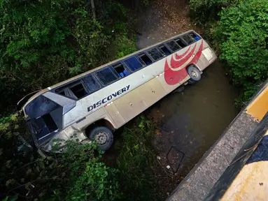 Gambar bus yang terjun ke sungai dangkal dekat Tegucigalpa, Honduras, Selasa (5/12/2023). Kecelakaan menewaskan 13 orang dan melukai puluhan lainnya. (Johny MAGALLANES/AFP)