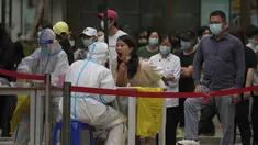 Warga saat diambil sampel usap tenggorokan selama pengujian virus corona massal di dekat kompleks perumahan dan perkantoran komersial di distrik Chaoyang, Beijing, Senin (25/4/2022). Pengujian massal dimulai Senin di distrik itu, rumah bagi lebih dari 3 juta orang di ibu kota China, menyusul wabah COVID-19 yang baru. (AP Photo/Andy Wong)