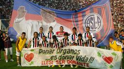 Klub San Lorenzo berfoto bersama dengan latar belakang Banner bergambar Paus Fransiskus sebelum pertandingan melawan Newell Old Boys di Buenos Aires pada 31 Maret 2013. (AFP/NA/Damian Dopacio)