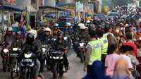 Polisi mengatur arus lalu lintas pemudik sepeda motor di Jalur Pantura Indramayu - Cirebon, Jawa Barat, Jumat (23/6). Pemudik bersepeda motor mendominasi jalur Pantura wilayah Kabupaten Indaramayu, memasuki H-2 Lebaran 2017. (Liputan6.com/Johan Tallo)