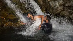 Dua pria bermain air di sungai saat musim panas di pinggiran Srinagar, Kashmir yang dikuasai India (4/7/2021). Musim panas waktu yang tepat untuk menghabiskan waktu di ruang terbuka hijau. Seperti warga Kashmir menikmati musim panas dengan pergi ke sungai. (AP Photo/Mukhtar Khan)
