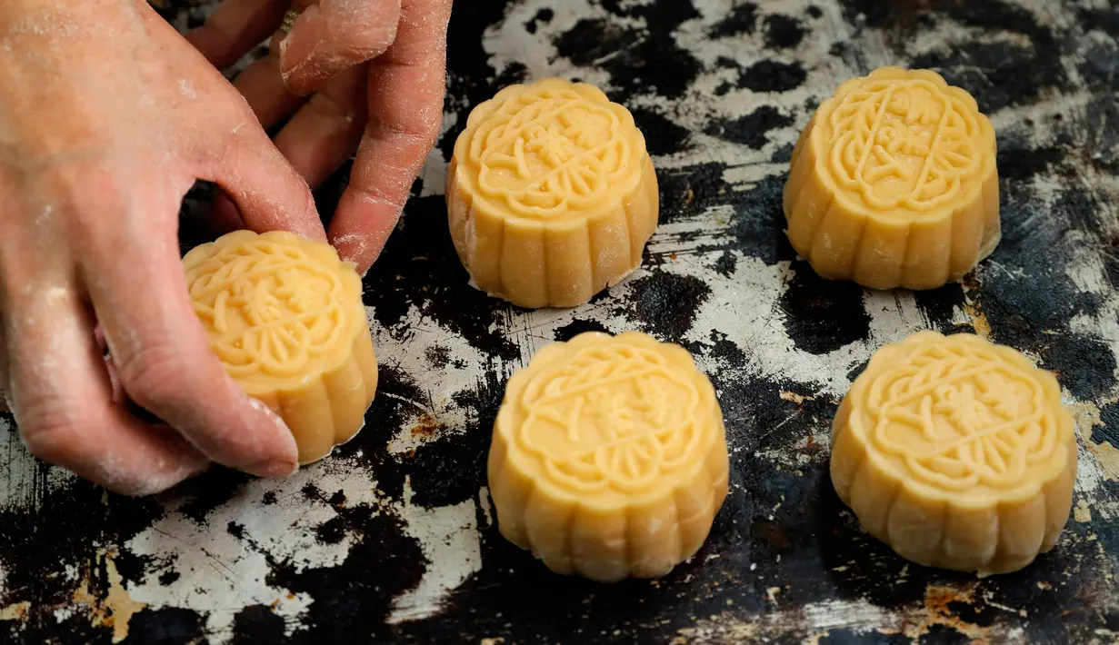 Pekerja menata kue bulan dengan cap kata-kata China 'orang Hong Kong' di toko roti Wah Yee Tang, Hong Kong, 9 Agustus 2019. Manager toko Naomi Suen mengatakan bahwa permintaan kue bulan akhir-akhir ini meningkat. (AP Photo/Kin Cheung)