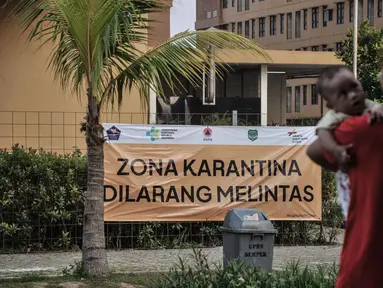 Aktivitas penghuni rusun di dekat tower yang difungsikan sebagai lokasi karantina pekerja migran Indonesia (PMI) atau WNI dari luar negeri di Rumah Susun Nagrak, Cilincing, Jakarta Utara, Rabu (5/1/2022). (merdeka.com/Iqbal S. Nugroho)