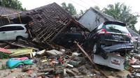 Tiga unit mobil tertimbun reruntuhan rumah yang rusak setelah tsunami menerjang kawasan Anyer, Banten, Minggu (23/12). Tsunami menerjang pantai di Selat Sunda, khususnya di daerah Pandenglang, Lampung Selatan, dan Serang. (Liputan6.com/Angga Yuniar)