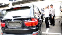 Polisi sedang menutup kaca BMW Rasyid Rajasa. Bagian belakang mobil masih mulus. (Liputan6.com/Helmi Fithriansyah)