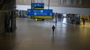 Seorang pria berjalan melalui bagian sepi bandara OR Tambo Johannesburg, Afrika Selatan (29/11/2021). WHO mendesak negara-negara di seluruh dunia untuk tidak memberlakukan larangan penerbangan di negara-negara Afrika selatan karena kekhawatiran atas varian omicron baru. (AP/Jerome Delay)