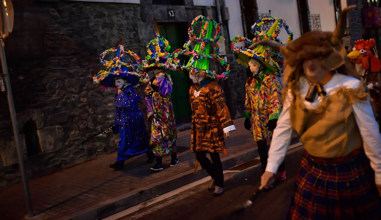 Peserta mengenakan kostum, topeng dan topi yang dikenal sebagai '' Ttutturo '' turun ke jalan saat mengikuti karnaval di desa Pyrenees Leitza, Spanyol (30/1). (AP Photo / Alvaro Barrientos)
