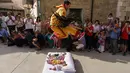 Pria berkostum setan melompati bayi-bayi yang terlentang di atas matras di sebuah jalan selama festival El Colacho di desa Castrillo de Murcia, bagian utara Spanyol, 23 Juni 2019. Festival melompati bayi ini sudah menjadi perayaan tahunan sejak tahun 1620. (CESAR MANSO/AFP)