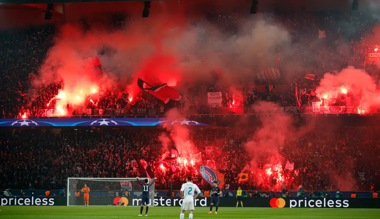 Suasana saat pertandingan Paris Saint-Germain melawan Real Madrid dalam pertandingan Liga Champions leg kedua di stadion Parc des Princes di Paris (6/3). Pendukung PSG menyalakan suar untuk menekan mental pemain Madrid. (AP Photo / Francois Mori)