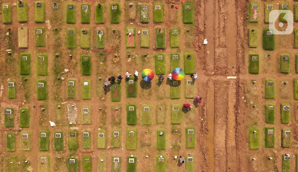 <p>Foto udara memperlihatkan warga melakukan ziarah di area pemakaman khusus COVID-19 di TPU Rorotan, Cilincing, Jakarta Utara, Rabu (4/5/2022). Sejumlah tempat pemakaman umum masih dipadati oleh keluarga yang melakukan ziarah di H+3 Lebaran. (merdeka.com/Imam Buhori)</p>