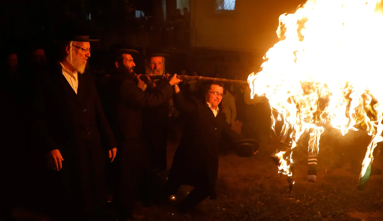 Sekelompok Yahudi ultra ortodoks antizionis menyalakan api unggun di Yerusalem ultra-Ortodoks Mea Shearim, Rabu (2/5). Dalam perayaan Lag BaOmer, ribuan orang Yahudi akan menyalakan api unggun besar. (MENAHEM KAHANA / AFP)