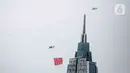 Helikopter TNI AU mengibarkan bendera Trimatra raksasa di kawasan Gedung DPR RI, Jakarta, Selasa (5/10/2021). Bendera yang dikibarkan berukuran 30 x 20 meter. (Liputan6.com/Faizal Fanani)