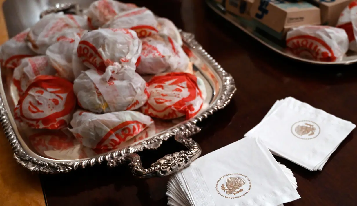 Burger memenuhi meja makan saat Presiden AS Donald Trump menjamu Clemson Tigers di Gedung Putih, Washington, Senin (14 /1). Trump mengaku menyukai semua makanan cepat saji yang disajikan. (AP Photo/Susan Walsh)