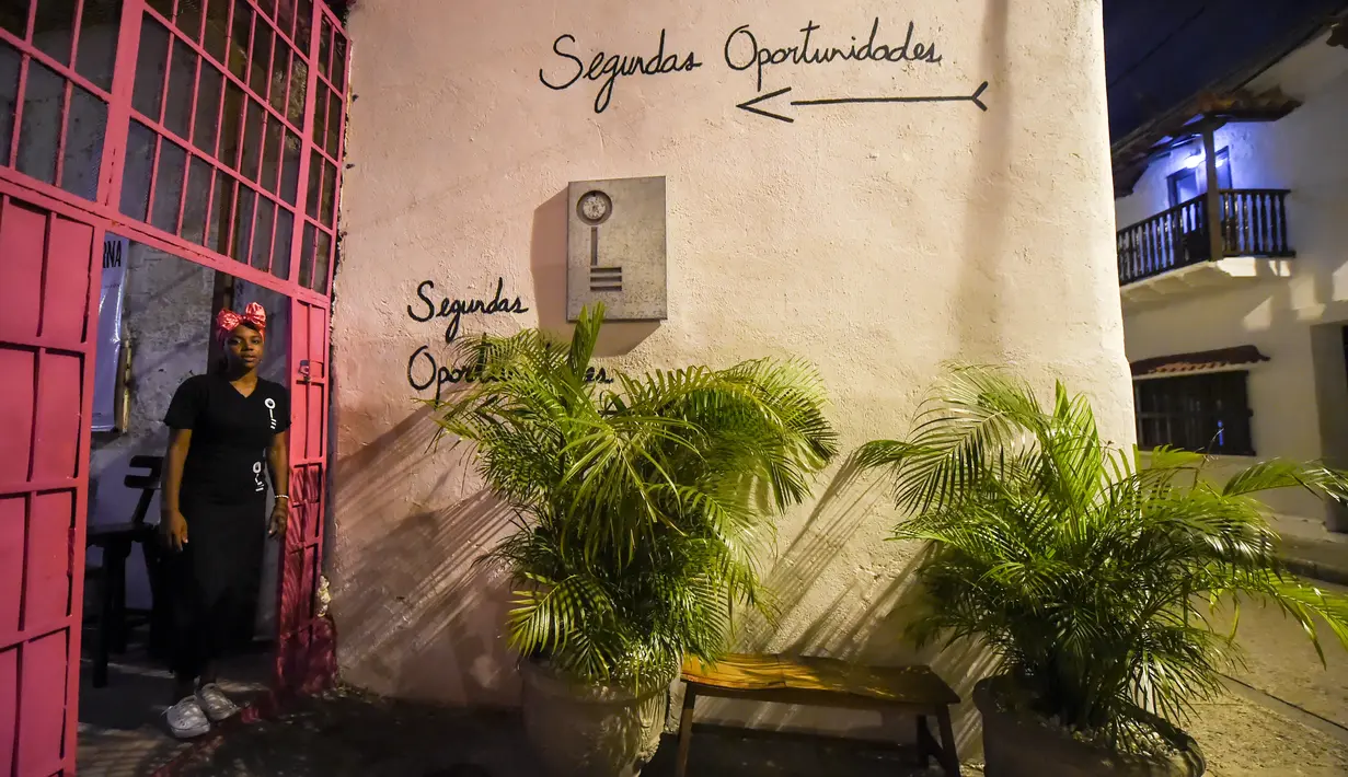 Seorang narapidana wanita, Arleth Martinez berdiri di pintu restoran Interno di Cartagena, Kolombia (24/8). Dengan adanya restoran ini narapidana wanita menerima pelatihan agar setelah bebas bisa diterima kembali oleh masyarakat. (AFP Photo/Raul Arboleda)