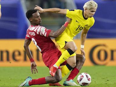 Pemain Yordania, Yazan Alarab, melewati pemain Malaysia, Darren Lok, dalam laga Grup E Piala Asia 2023 yang digelar di Al Janoub Stadium, Al Wakrah, Selasa (16/1/2024). Malaysia takluk empat gol tanpa balas. (AP Photo/Aijaz Rahi)