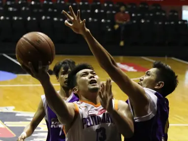 Pemain Pelita Jaya, Ponsianus Indrawan (kiri) mencoba memasukkan bola ke jaring CLS Knights dalam semi final NBL Championship Series. Kamis (7/5). CLS Knights menang 61-56 dalam pertandigan tersebut. (bola.com/Arief Bagus)