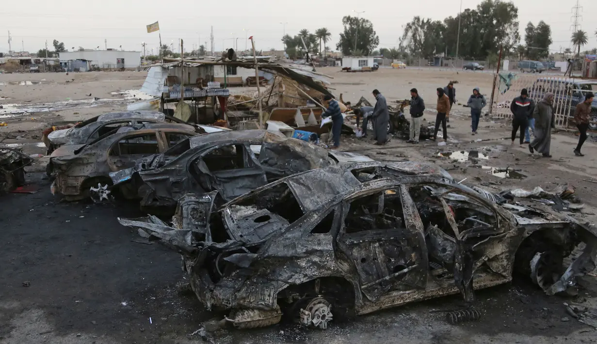 Sejumlah orang melihat-lihat di lokasi terjadinya ledakan bom mobil di permukiman al-Bayaa, Irak, Kamis (16/2). Pihak keamanan dan sumber medis mengatakan sedikitnya 48 orang tewas dan melukai 55. (AP Photo/ Karim Kadim) 