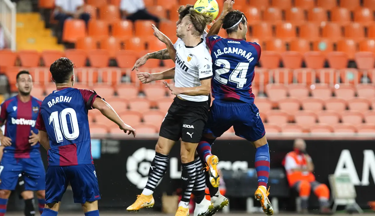 Pemain Valencia, Daniel Wass berebut bola udara dengan pemain Levante, Jose Campana pada pertandingan La Liga Spanyol di Stadion Mestalla di Valencia, Spanyol, Minggu, (13/9/2020). Valencia menang telak 4-2. (AP Photo/Alberto Saiz)