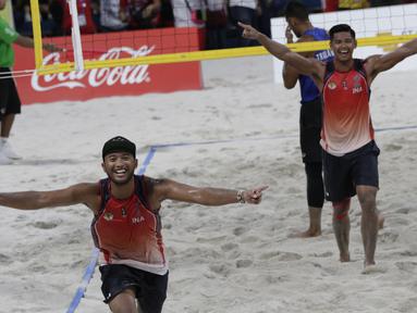Pevoli pantai Indonesia, Gilang Pribadi dan Danangsyah, merayakan kemenangan atas Thailand pada laga final voli pantai beregu putra SEA Games di Subic Court Tennis, Filipina, Jumat (6/12). Indonesia berhasil meraih emas. (Bola.com/M Iqbal Ichsan)