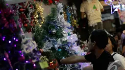Sejumlah pengunjung memilih pohon Natal beserta hiasannya di Pasar Mangga Dua, Jakarta, Sabtu (13/12/2014). (Liputan6.com/Johan Tallo)
