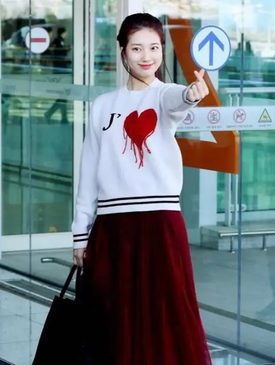 Untuk outfit sehari-hari, kamu bisa memakai tutu skirt yang dipadukan dengan sweater dengan motif manis yang berwarna senada. Seperti look Suzy saat di bandara ini. (Instagram/ skuukzky)