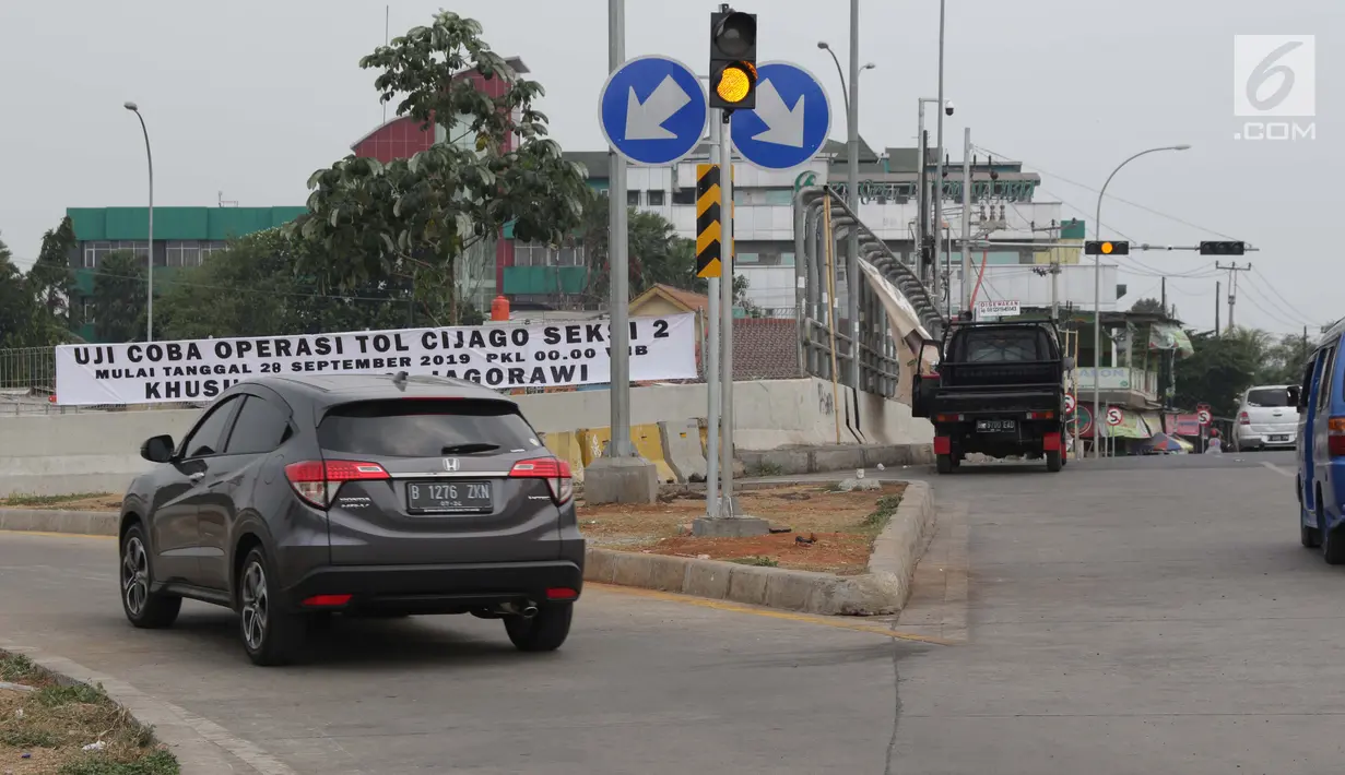Spanduk uji coba operasi tol Cijago seksi 2 terpasang di Depok, Jawa Barat, Sabtu (28/9/2019). Gerbang tol Cijago seksi 2 (Jl Raya Bogor-Kukusan) sepanjang 5,5 km dapat dilalui secara fungsional mulai Sabtu (28/9) pukul 00.00 WIB. (Liputan6.com/Helmi Fithriansyah)