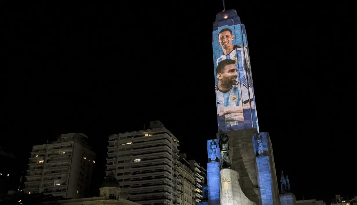Video mapping memperlihatkan gambar bintang sepak bola Argentina Lionel Messi dan Angel Di Maria di "Monumento Nacional a la Bandera" di Rosario, Senin (21/11/2022). Proyeksi cahaya tersebut sebagai bentuk untuk menyemangati timnas Argentina sebelum menghadapi Arab Saudi dalam laga pertama Grup C Piala Dunia 2022, Selasa (22/11/2022) petang WIB. (Marcelo Manera / AFP)