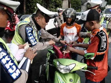Petugas kepolisian merazia  suporter yang membawa barang berbahaya disekitar kawasan Gelora Bung Karno, Jakarta, Minggu (8/5/2016). Razia tersebut dilakukan untuk mengatisipasi keributan antar supporter. (Liputan6.com/Faizal Fanani)