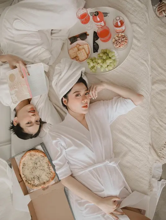 Sama-sama memakai robe putih, keduanya berpose di atas tempat tidur sambil memanjakan diri dengan buku dan makanan. (IG: @danitasigarlaki)