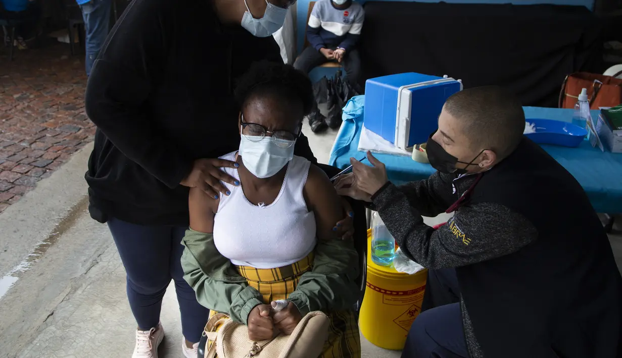 Seorang perempuan muda disuntik vaksin COVID-19 di sebuah lokasi dekat Johannesburg, Rabu (8/12/2021). Kasus Omicron telah dikonfirmasi setidaknya di sembilan negara Afrika, dengan Afrika Selatan tetap menjadi episenter awal ditemukannya varian baru tersebut. (AP Photo/Denis Farrell)