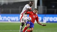 Pemain Cile Alexis Sanchez mencoba menendang bola ke gawang, dibayangi pemain Peru Luis Advincula dalam pertandingan Grup Copa America 2024 di Stadion AT&amp;T pada Sabtu (22/6/2024) pagi WIB di Arlington, Texas. Meski banyak menciptakan peluang di babak pertama, Sanchez gagal menyumbang gol bagi timnya, sehingga laga berakhir dengan 0-0. (Omar Vega/Getty Images/AFP)