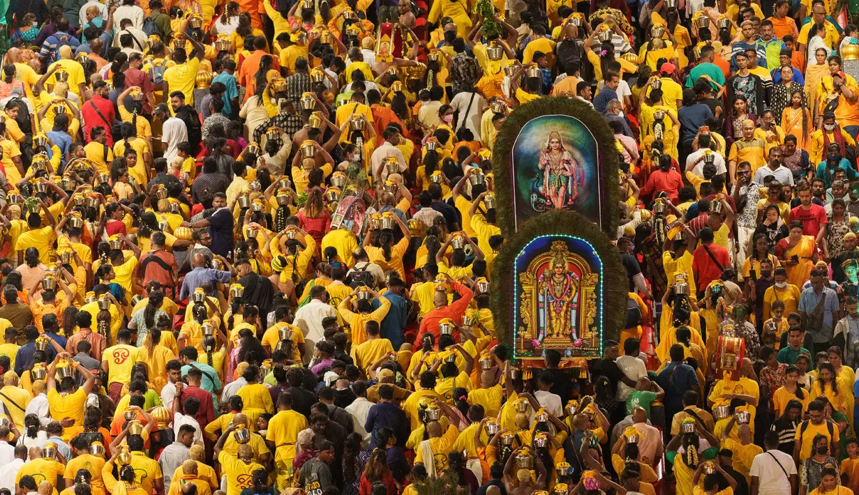 Umat Hindu membawa kanopi berhias yang disebut “kavadi” saat menaiki 272 anak tangga menuju Kuil Sri Subramaniar Swamy pada perayaan Thaipusam di Batu Caves, Kuala Lumpur, Malaysia, Minggu (5/2/2023). Thaipusam, yang dirayakan untuk menghormati Dewa Murugan, adalah acara tahunan umat Hindu untuk mencari berkah, memenuhi sumpah, dan mengucapkan terima kasih. (AP Photo/Vincent Thian)