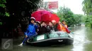 Sejumlah warga selfie diatas perahu karet saat dievakuasi petugas di perumahan Pondok Hijau Permai, Bekasi. (Liputan6.com/Gempur M. Surya)