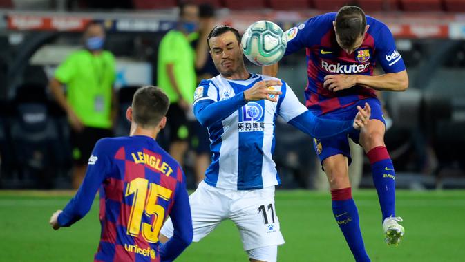 Pemain Espanyol, Javier Puado (kiri) berebut bola dengan bek Barcelona, Jordi Alba pada lanjutan pertandingan La Liga Spanyol di Camp Nou, Kamis (9/7/2020) dini hari WIB.  Barcelona menang tipis 1-0 atas Espanyol lewat gol yang dicetak Luis Suarez. (LLUIS GENE / AFP)