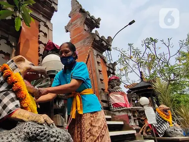 Umat Hindu memasang hiasan di Pura Kerta Jaya, Kota Tangerang, Banten, Selasa (15/9/2020). Persiapan tersebut dilakukan jelang Hari Raya Galungan yang jatuh pada 16 September 2020. (Liputan6.com/Angga Yuniar)