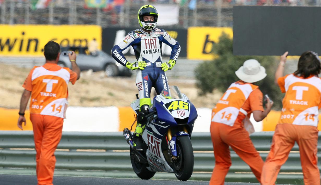 Valentino Rossi berdiri di atas motornya saat merayakan kemenangan dalam MotoGP di Portugal pada September 2007. (AFP/Francisco Leong)