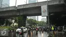 Pengendara sepeda motor berteduh di bawah flyover saat hujan turun, Jakarta, Rabu (13/7). Petugas kepolisian akan menerapkan tilang dengan denda maksimal Rp250.000 untuk pengendara yang berteduh di bawah flyover. (Liputan6.com/Gempur M Surya) 